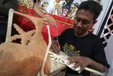 Perajin menyelesaikan pembuatan wayang krucil berbahan baku kayu mentaos di Kediri, Jawa Timur, Rabu (10/7/2019). Berbagai karakter tokoh wayang krucil tersebut dijual secara daring dengan harga Rp350.000 sampai Rp700.000 per unit. Antara Jatim/Prasetia Fauzani/zk.