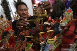 Perajin menata wayang krucil berbahan baku kayu mentaos di Kediri, Jawa Timur, Rabu (10/7/2019). Berbagai karakter tokoh wayang krucil tersebut dijual secara daring dengan harga Rp350.000 sampai Rp700.000 per unit. Antara Jatim/Prasetia Fauzani/zk.