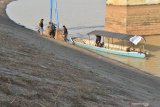 Sejumlah penumpang turun dari perahu di dekat pintu Waduk Dawuhan, Kabupaten Madiun, Jawa Timur, Rabu (10/7/2019). Akibat musim kemarau, waduk seluas 1.273 hektare dan memiliki daerah irigasi seluas 2.823 hektare tersebut mengalami penyusutan volume dengan penurunan permukaan air waduk sekitar empat meter. Antara Jatim/Siswowidodo/zk.