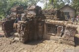 Penggiat sejarah menikmati suasana sembari duduk di anak tangga pintu masuk Candi Mirigambar di kompleks Candi Mirigambar, Tulungagung, Jawa Timur, Kamis (11/7/2019). Edukasi sejarah itu dimaksudkan agar anak-anak lebih mengenal dan ikut melestarikan warisan cagar budaya bangsa, di lingkungan dimana mereka tumbuh dan berkembang. Antara Jatim/Destyan Sujarwoko/zk.