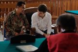 Warga negara Rusia, Andrei Zhestkov (kedua kanan) mendapat penjelasan dari petugas penerjemah saat menjalani sidang kasus penyelundupan orangutan di Pengadilan Negeri Denpasar, Bali, Kamis (11/7/2019). Majelis hakim menjatuhkan setahun penjara dan denda Rp10 juta subsider 2 bulan pidana kurungan bagi Andrei Zhestkov karena dinyatakan terbukti bersalah yaitu berupaya menyelundupkan orangutan lewat Bandara Ngurah Rai ke negaranya pada 22 Maret 2019. ANTARA FOTO/Nyoman Hendra Wibowo/nym.