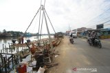 Sejumlah pekerja menyelesaikan jembatan darurat di samping Jembatan Sungai Gardu I, Banjarmasin, Kalimantan Selatan, Jumat (12/7/2019).Proyek pembangunan tiga jembatan di wilayah Sungai Lulut dengan anggaran 17,5 Miliar tersebut mulai di kerjakan yang di awali pembuatan jembatan darurat di samping Jembatan Sungai Gardu I.Foto Antaranews Kalsel/Bayu Pratama S.