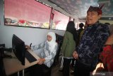 Gubernur Jawa Timur Khofifah Indar Parawansa (kiri) didampingi Wakil Ketua KPK Thony Saut Situmorang (kanan) mencoba aplikasi antikorupsi saat 