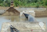 Mobil truk dan alat berat menumpukan material tanah untuk menahan arus sungai saat perbaikan tanggul karet Perusahaan Daerah Air Munum Tirta Daroy Banda Aceh, di kawasan Lambaro, Kabupaten Aceh Besar, Aceh, Sabtu (13/7/2019). Perbaikan tanggul karet yang bocor itu untuk memperlancar dan meningkatkan volume distribusi air baku ke instalasi pengolahan air minum PDAM guna memenuhi kebutuhan air bersih masyarakat. (Antara Aceh/Ampelsa)