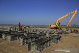 Pekerja menyelesaikan pembuatan beton pemecah ombak di pantai Juntinyuat, Indramayu, Jawa Barat, Minggu (14/7/2019). Beton pemecah ombak yang dipasang di beberapa titik di pantai tersebut untuk menahan abrasi pantai, serta banjir rob akibat air pasang yang kian mengikis daratan. ANTARA JABAR/Dedhez Anggara/agr