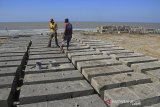 Pekerja menyelesaikan pembuatan beton pemecah ombak di pantai Juntinyuat, Indramayu, Jawa Barat, Minggu (14/7/2019). Beton pemecah ombak yang dipasang di beberapa titik di pantai tersebut untuk menahan abrasi pantai, serta banjir rob akibat air pasang yang kian mengikis daratan. ANTARA JABAR/Dedhez Anggara/agr