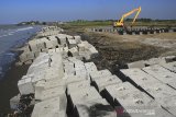 Pekerja menyelesaikan pembuatan beton pemecah ombak di pantai Juntinyuat, Indramayu, Jawa Barat, Minggu (14/7/2019). Beton pemecah ombak yang dipasang di beberapa titik di pantai tersebut untuk menahan abrasi pantai, serta banjir rob akibat air pasang yang kian mengikis daratan. ANTARA JABAR/Dedhez Anggara/agr