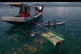 Bocah nelayan mendayung perahunya di dekat serakan sampah laut yangmengapung di perairan Tanjung Batu, Donggala, Sulawesi Tengah, Minggu (14/7/2019). Untuk menangani masalah sampah laut, pemerintah telah menerbitkan Peraturan Presiden Nomor 83 Tahun 2018 tentang Penanganan Sampah Laut yang berisi strategi, program, dan kegiatan yang terukur, terarah untuk mengurangi jumlah sampah di laut, terutama sampah plastik. ANTARA FOTO/Basri Marzuki/nym.