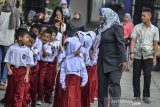 Siswa baru kelas satu Sekolah Dasar Negeri Pengadilan berbaris disaksikan orang tua muridnya di Kota Tasikmalaya, Jawa Barat, Senin (15/7/2019). Hari pertama masuk sekolah tahun ajaran 2019-2020 dimulai serentak dan para orang tua siswa hadir mengantar anaknya untuk mengenal lingkungan sekolah serta berinteraksi dengan pihak sekolah dan guru. ANTARA JABAR/Adeng Bustomi/agr