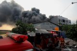 Petugas memadamkan api yang membakar bangunan di komplek pergudangan Mutiara Jalan Tambak Langon, Surabaya, Jawa Timur, Senin (15/7/2019). Sekitar 17 unit kendaraan pemadam kebakaran serta dua unit Bronto Sky Lift dikerahkan untuk memadamkan kebakaran bangunan 'Cold Storage' berlantai tiga dengan lebar sekitar 30 meter dan panjang sekitar 54 meter yang sedang dalam proses penyelesaian pembangunan itu. Antara Jatim/Didik Suhartono/ZK