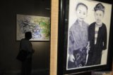 Pengunjung mengamati seni lukis dalam pameran seni lukis dan foto 