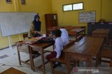 Guru mulok, Sriami mengajar dua orang siswa kelas 1 SDN Sumberaji 2 di Dusun Ngapus, Desa Sumberaji, Kecamatan Kabuh, Jombang, Jawa Timur, Selasa (16/7/2019). SDN tersebut merupakan sekolah khusus untuk anak-anak Dusun Ngapus yang merupakan wilayah terpecil dan jauh dari pusat kota, saat ini seluruh siswanya berjumlah 11 orang. Yakni siswa kelas I sebanyak 2 orang, siswa kelas IV 4 orang serta kelas V sebanyak 6 orang siswa. Antara Jatim/Syaiful Arif/zk.