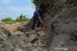 David Widodo menunjukkan strukur batu bata kuno di lokasi bekas galian C di Dusun Wangkalkerep, Desa Karangtengah, Kecamatan Kandangan, Kabupaten Kediri, Jawa Timur, Selasa (16/7/2019). Penemuan struktur batu bata kuno di bekas galian tanah uruk yang berbatasan dengan wilayah Kabupaten Jombang tersebut diduga merupakan bangunan candi, namun sudah banyak batu bata yang ditemukan dalam kondisi hancur serta tidak adanya respon dari pemda setempat. Antara Jatim/Syaiful Arif/zk.