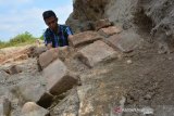 David Widodo menunjukkan strukur batu bata kuno di lokasi bekas galian C di Dusun Wangkalkerep, Desa Karangtengah, Kecamatan Kandangan, Kabupaten Kediri, Jawa Timur, Selasa (16/7/2019). Penemuan struktur batu bata kuno di bekas galian tanah uruk yang berbatasan dengan wilayah Kabupaten Jombang tersebut diduga merupakan bangunan candi, namun sudah banyak batu bata yang ditemukan dalam kondisi hancur serta tidak adanya respon dari pemda setempat. Antara Jatim/Syaiful Arif/zk.