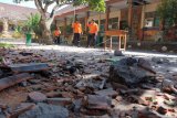 Petugas BPBD Badung memeriksa kondisi bangunan SD No. 1 Ungasan yang rusak di bagian atap akibat gempa bumi di Badung, Bali, Selasa (16/7/2019). Gempa bumi berkekuatan 6.0 SR yang berlokasi di wilayah Samudera Hindia Selatan Bali-Nusa Tenggara tersebut mengakibatkan genteng sekolah runtuh sehingga menyebabkan seorang guru dan tiga siswa terluka. ANTARA FOTO/Nyoman Hendra Wibowo/nym