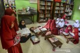 Siswa kelas 2 Sekolah Dasar Negeri (SDN) Cikadongdong mengikuti Kegiatan Belajar Mengajar (KBM) dilantai ruang perpustakaan di Singaparna, Kabupaten Tasikmalaya, Jawa Barat, Rabu (17/7/2018). Akibat kekurangan ruang kelas, sebanyak 19 siswa terpaksa belajar tidak menggunakan kursi, padahal pihak sekolah sudah kerap kali mengajukan kepada pemerintah setempat untuk menyediakan ruang kelas baru namun hingga saat ini belum terealisasi. ANTARA JABAR/Adeng Bustomi/agr