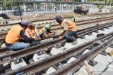 Pekerja memasang rel pada bantalan saat pembangunan jalur ganda Kereta Api (KA) lintas selatan di kawasan Stasiun KA Madiun, Jawa Timur, Rabu (17/7/2019). Jalur ganda KA lintas selatan ditargetkan selesai pada 2019. Antara Jatim/Siswowidodo/zk.