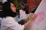 Seniman Batik Lukis Jawa Timur, Tjiplies Pudji Lestari (kiri) dan Budi Wuryanto (kanan) membuat karya batik lukis saat pameran bertajuk 