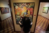 Pengunjung melihat batik lukis karya Komunitas Batik Lukis Jawa Timur yang dipajang saat pameran bertajuk 
