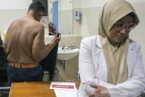 Pasien eks penderita obesitas Arya Permana (kiri) didampingi Dokter Spesialis Anak dan Gizi Anak melepas pakaian untuk  pengukuran untuk pemeriksaan awal di RSUP Hasan Sadikin, Bandung, Jawa Barat, Rabu (17/7/2019). Arya Permana yang telah berhasil menurunkan berat badan dari 190 kg menjadi 85 kg tersebut dijadwalkan akan menjalani operasi bedah plastik untuk menghilangkan gelambir atau lipatan kulit pada 24 juli mendatang. ANTARA JABAR/Novrian Arbi/agr