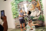 Dua wisatawan berpose di atas lukisan tiga dimensi di The Borneo House Museum di Kuching, Sarawak, Malaysia, Selasa (16/7/2019). The Borneo House Museum menyajikan sejumlah karya lukis dan instalasi seni tiga dimensi bertajuk wisata alam, budaya, kuliner dan kehidupan masyarakat di Sarawak. ANTARA FOTO/Jessica Helena WuysangANTARA FOTO/JESSICA HELENA WUYSANG (ANTARA FOTO/JESSICA HELENA WUYSANG)