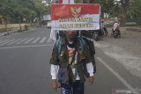 Seorang aktivis demokrasi, Medi Bastoni melakukan aksi jalan mundur di jalan raya Tulungagung, Jawa Timur, Kamis (18/7/2019). Solo aksi yang dimulai dari Pendopo Kabupaten Tulungagung menuju Istana Negara, Jakarta itu dilakukan dalam rangka memperingati HUT ke-74 Kemerdekaan RI sekaligus bentuk dukungan atas terpilihnya kembali Presiden Joko Widodo untuk periode pemerintahan 2019-2024. Antara Jatim/Destyan Sujarwoko/zk