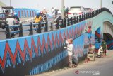 Pekerja sedang menyelesaikan cat motif sasirangan di Jembatan Pangeran, Banjarmasin, Kalimantan Selatan, Senin (18/7/2019).Pemerintah Kota Banjarmasin terus berupaya mempercantik Kota Banjarmasin salah satunya dengan mecat jembatan Pangeran dengan motif sasirangan.Foto Antaranews Kalsel/Bayu Pratama S.