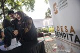 Direktur Group Manajemen Risiko Lembaga LPS Dewi Gayatri (kanan) mendampingi anak-anak saat menimbang berat badan seusai peresmian Desa GEMPITA (Gerakan Menu Empat Bintang) di Bandung, Jawa Barat, Kamis (18/7/2019). Kegiatan tersebut bertujuan untuk pencegahan dan penanggulangan stunting melalui pemberian makanan tambahan harian selama enam bulan kepada balita dan ibu hamil yang membutuhkan dan edukasi kesehatan secara umum, serta program pengembangan posyandu. ANTARA JABAR/M Agung Rajasa/agr