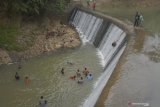 Warga berpakaian adat melempar kepala kerbau ke dasar bendung irigasi Dam Bagong, Trenggalek, Jawa Timur, Jumat (19/7/2019). Ritual nyadran itu diigelar setiap Jumat Kliwon bulan Selo dalam penanggalan Jawa, dengan tujuan menjaga dan melestarikan nilai-nilai kearifan lokal sekaligus bentuk syukur atas keberadaan bendung irigasi yang selama ini mengairi ribuan hektare sawah di empat kecamatan setempat itu. Antara Jatim/Destyan Sujarwoko/zk.