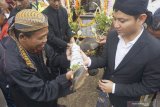 Bupati Trenggalek Mochammad Nur Arifin (kanan) menerima potongan organ kaki hewan kerbau yang telah disembelih, dan untuk selanjutnya dilarung ke dasar bendung irigasi Dam Bagong, Trenggalek, Jawa Timur, Jumat (19/7/2019). Ritual nyadran itu diigelar setiap Jumat Kliwon bulan Selo dalam penanggalan Jawa, dengan tujuan menjaga dan melestarikan nilai-nilai kearifan lokal sekaligus bentuk syukur atas keberadaan bendung irigasi yang selama ini mengairi ribuan hektare sawah di empat kecamatan setempat itu. Antara Jatim/Destyan Sujarwoko/zk.