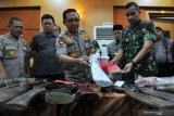 Kapolda Jambi Irjen Pol Muchlis (tengah), Pangdam II Sriwijaya Mayjen TNI Irwan (kedua kanan), Gubernur Jambi Fachrori Umar (ketiga kanan) dan petugas terkait memeriksa barang bukti saat rilis kasus tindak pidana penghadangan, perusakan dan penganiayaan di Mapolda Jambi, Jumat (19/7/2019). Polda Jambi menetapkan 20 tersangka dari kelompok Serikat Mandiri Batanghari (SMB) pimpinan Muslim dalam kasus tindak pidana penghadangan, perusakan dan penganiayaan terhadap tim Satgas Pencegahan Karhutla (kebakaran hutan dan lahan) Jambi saat bertugas di wilayah konsesi PT Wirakarya Sakti (WKS), Tanjungjabung Barat, Jambi pada Kamis (18/7/2019) sore serta mengamankan puluhan senjata api rakitan dan senjata tajam. ANTARA FOTO/Wahdi Septiawan/wsj.