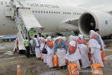 Jamaah calon haji menaiki pesawat di Bandar Udara Internasional Sultan Iskandar Muda, Aceh Besar, Sabtu (20/7/2019). Panitia Penyelenggara Ibadah Haji (PPIH) Aceh membagi 12 kelompok terbang (kloter), sebanyak 393 CJH kloter 1 diberangkatkan dari Embarkasi Aceh. (Antara Aceh/Khalis)