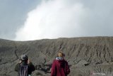 Wisatawan melihat pemandangan gunung Bromo yang mengalami erupsi dari kawasan lautan pasir di Probolinggo, Jawa Timur, Sabtu (20/7/2019). Pusat Vulkanologi Mitigasi Bencana Geologi (PVMBG) menghimbau masyarakat dan wisatawan tidak mendekat kawasan kawah Gunung Bromo sejauh radius satu kilometer. Antara Jatim/Vermensius Onggat Gebze/abs/zk