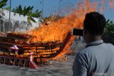 Warga mengabadikan pembakaran replika kapal saat memperingati Dewi Kwan Im mencapai kesempuranaan di Vihara Avalokitesvara, Pamekasan, Jawa Timur, Sabtu (20/7/2019). Umat Budha dari sejumlah daerah beribadah di vihara tersebut guna memperoleh 'welas asih' dan kesuksesan serta keselamatan dimasa yang akan datang. Antara Jatim/Saiful Bahri/zk.