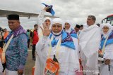 Jamaah calon haji melambaikan tangan kepada keluarganya saat menaiki pesawat di Bandara Sultan Iskandar Muda Aceh Besar, Aceh, Sabtu (20/7/2019). Panitia Penyelenggara Ibadah Haji (PPIH) Aceh membagi 12 kelompok terbang (kloter), sebanyak 393 CJH kloter 1 diberangkatkan dari Embarkasi Aceh. (Antara Aceh/Khalis)