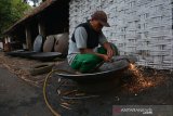 Pekerja memotong bagian tepi wajan berukuran jumbo di Desa Kebondalem, Kecamatan Bareng, Jombang, Jawa Timur, Sabtu (20/7/2019). Wajan berukuran jumbo berbahan besi bekas kapal itu dijual Rp 21.000 per kilogramnya dengan berat rata-rata satu buah wajan 50-70 Kg. Antara Jatim/Syaiful Arif/zk