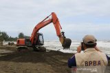 Kepala Badan Penanggulangan Bencana Aceh (BPBA) T Ahmad Dadek (kanan) melihat proses pembersihan badan jalan di Desa Suak Indrapuri, Johan Pahlawan, Aceh Barat, Minggu (21/7/2019). Data Badan Penanggulangan Bencana Aceh (BPBA) menyebutkan abrasi pantai yang terjadi di Kabupaten setempat merobohkan dua kilometer tanggul pengaman pantai yang tersebar di Desa Suak Indrapuri, Gampong Pasir dan Desa Ujong Kalak, dan hingga saat ini pihak BPBA telah menurunkan dua unit alat berat untuk membersihkan material yang menutupi badan jalan antar Desa serta memberikan bantuan goni pasir untuk pembuatan tanggul darurat. (Antara Aceh/Syifa Yulinnas)