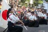 Warga menyaksikan penampilan peserta dari negara Jepang pada parade lintas budaya di Jalan Tunjungan, Surabaya, Jawa Timur, Minggu (21/7/2019). Kegiatan itu merupakan rangkaian Surabaya Cross Culture International Folk Art Festival 2019 yang diikuti oleh sebelas negara dan lima kota dari Indonesia. Antara Jatim/Didik Suhartono/ZK