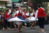 Warga menyaksikan penampilan peserta dari negara Ceko pada parade lintas budaya di Jalan Tunjungan, Surabaya, Jawa Timur, Minggu (21/7/2019). Kegiatan itu merupakan rangkaian Surabaya Cross Culture International Folk Art Festival 2019 yang diikuti oleh sebelas negara dan lima kota dari Indonesia. Antara Jatim/Didik Suhartono/ZK