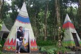 Wisatawan memasuki wahana Indian Camp di Wana Wisata Coban Jahe, Malang, Jawa Timur, Minggu (21/7/2019). Obyek wisata seluas 10 hektare yang berada di kawasan RPH Sukopuro Jabung tersebut mengandalkan keindahan alam dan berbagai wahana petualangan untuk menarik wisawan agar datang berkunjung saat libur akhir pekan. Antara Jatim/Ari Bowo Sucipto/zk.