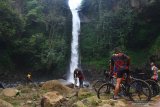 Wisatawan menikmati pemandangan air terjun di Wana Wisata Coban Jahe, Malang, Jawa Timur, Minggu (21/7/2019). Obyek wisata seluas 10 hektare yang berada di kawasan RPH Sukopuro Jabung tersebut mengandalkan keindahan alam dan berbagai wahana petualangan untuk menarik wisawan agar datang berkunjung saat libur akhir pekan. Antara Jatim/Ari Bowo Sucipto/zk.