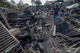 Warga membawa puing yang masih bisa terpakai pascakebakaran toko kayu di Bandung, Jawa Barat, Selasa (23/7/2019). Kebakaran yang belum diketahui penyebabnya pada Selasa (23/7) dini hari tersebut menghanguskan sebuah sejumlah toko kayu, toko buku serta warung yang berada di sekitar tempat kejadian. ANTARA JABAR/Raisan Al Farisi/agr