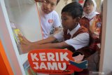 Sejumlah pelajar sekolah dasar meminjam buku di perpustakaan mini Kerik Jamu (Tuker Plastik - Pinjam Buku) di Alfamart Jalan Ciliwung, Surabaya, Jawa Timur, Selasa (23/7/2019). Perpustakaan mini Kerik Jamu yang digagas oleh Oliver Utomo Budiman dan tersebar di 50 toko Alfamart di kawasan Kota Surabaya, Gresik dan Sidoarjo itu menyediakan berbagai macam buku untuk anak hanya dengan menukarkan sampah plastik dan bertujuan untuk meningkatkan minat baca serta menanamkan rasa peduli sampah plastik sejak dini. Antara Jatim/Didik Suhartono/ZK