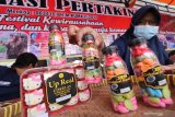 Eks pekerja migran menata cokelat buatannya di stan pameran Festival Kewirausahaan Pekerja Migran Indonesia di Desa Kanigoro, Kediri, Jawa Timur, Rabu (24/7/2019). Kegiatan pameran wirausaha dan pertunjukan seni yang diselenggarakan Kementerian Ketenagakerjaan tersebut bertujuan mensosialisasikan cara menjadi pekerja migran legal kepada masyarakat sekaligus mengajak eks pekerja migran untuk berwirausaha. Antara Jatim/Prasetia Fauzani/zk.