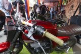 Warga mengamati motor modifikasi di salah satu stan pameran Festival Kewirausahaan Pekerja Migran Indonesia di Desa Kanigoro, Kediri, Jawa Timur, Rabu (24/7/2019). Kegiatan pameran wirausaha dan pertunjukan seni yang diselenggarakan Kementerian Ketenagakerjaan tersebut bertujuan mensosialisasikan cara menjadi pekerja migran legal kepada masyarakat sekaligus mengajak eks pekerja migran untuk berwirausaha. Antara Jatim/Prasetia Fauzani/zk.