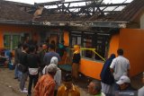 Warga melihat Tempat Kejadian Perkara (TKP) kebakaran di sebuah rumah di Junrejo, Batu, Jawa Timur, Rabu (24/7/2019). Kebakaran tersebut mengakibatkan empat orang anak tewas. Antara Jatim/Ari Bowo Sucipto/zk