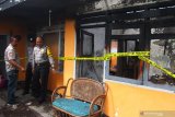 Polisi berjaga di Tempat Kejadian Perkara (TKP) kebakaran di sebuah rumah di Junrejo, Batu, Jawa Timur, Rabu (24/7/2019). Kebakaran tersebut mengakibatkan empat orang anak tewas. Antara Jatim/Ari Bowo Sucipto/zk