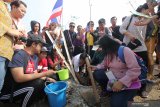 Peserta Cross Culture International Folk Art Festival menanam pohon di Taman Hiburan Pantai Kenjeran, Surabaya, Jawa Timur, Rabu (24/7/2019). Kegiatan itu merupakan rangkaian Surabaya Cross Culture International Folk Art Festival 2019 yang diikuti 13 negara dan lima provinsi dari Indonesia. Antara Jatim/Didik Suhartono/ZK