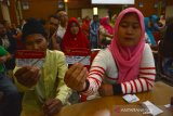 Keluarga Penerima Manfaat (KPM) menunjukkan Kartu Keluarga Sejahtera saat mengikuti sosialisasi dan edukasi bantuan sosial nontunai di Pemkab Jombang, Jawa Timur, Rabu (24/7/2019). Kementerian Keuangan (Kemenkeu) mencatat realisasi penyaluran bantuan sosial (bansos) hingga Juni 2019 mencapai Rp 70,49 triliun. Angka tersebut telah mencapai 72,63 persen terhadap pagu anggaran yang ditetapkan dalam APBN 2019. Antara Jatim/Syaiful Arif/zk