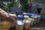 Warga mengisi air bersih di salah satu sumur swadaya di Desa Cibungur, Batujajar Timur, Kabupaten Bandung Barat, Jawa Barat, Rabu (24/7/2019). Warga menyatakan semenjak adanya pabrik di kawasan tersebut, sumur di pemukiman warga mengering sehingga warga terpaksa antre untuk kebutuhan air bersih di sumur swadaya masyarakat. ANTARA JABAR/Raisan Al Farisi/agr